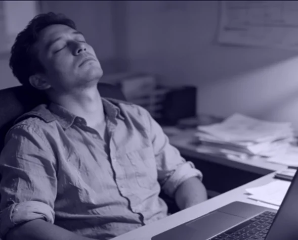 Small business owner at a desk with a laptop looking stressed while considering a web design service in Johannesburg.